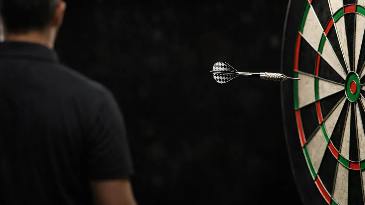 Darts-Spieler beim konzentrierten Wurf am Oche aus der Nahaufnahme