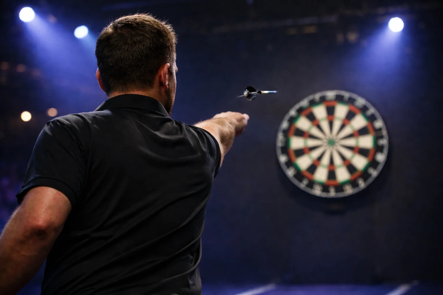Ein Dartspieler wirft konzentriert einen Pfeil auf die Dartscheibe unter Bühnenbeleuchtung — Symbolbild für deutsche PDC-Profis